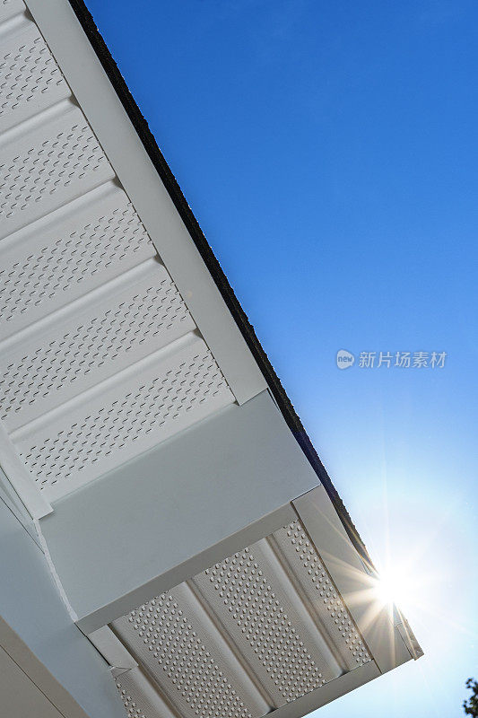 Looking up at newly installed fascia and perforated soffit – sun flare
